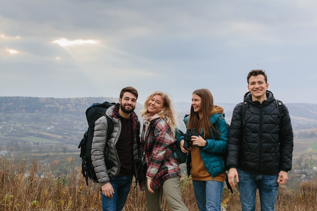 Vrienden genieten van de zonnestralen die door de wolken in de bergen schijnen