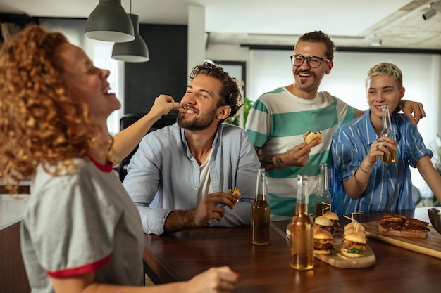 Vrienden genieten van eten en drinken terwijl ze thuis de dag samen doorbrengen