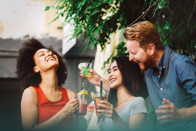 Vrienden hebben een geweldige tijd in café. Vrienden glimlachen, praten en zitten in een coffeeshop, smoothie drinken en samen genieten.