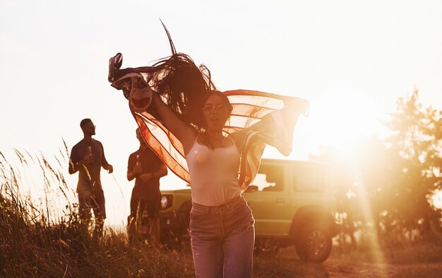 Vrienden hebben een leuk weekend buiten in de buurt van hun groene auto met Amerikaanse vlag