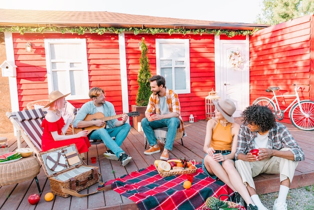 Vrienden hebben een picknick en spelen met gitaar