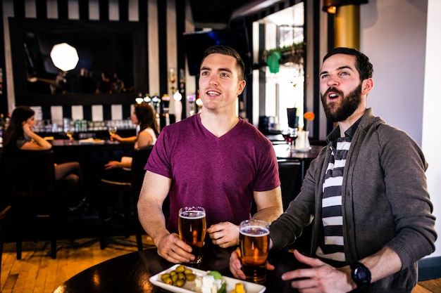 Vrienden hebben een pint in een bar