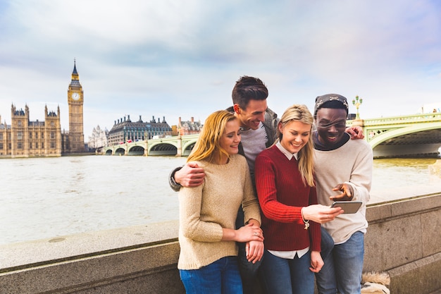 Vrienden hebben plezier met smartphone in de Big Ben in Londen