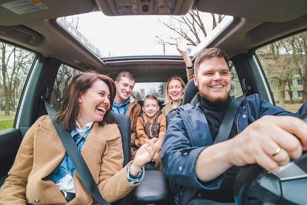 Vrienden in de auto met een klein kinderauto-reisconcept