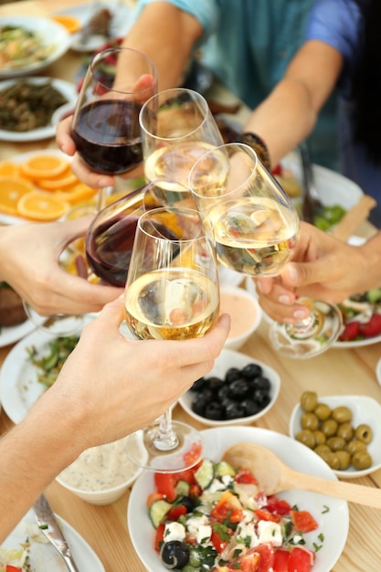 Vrienden juichen met glazen wijn op picknick