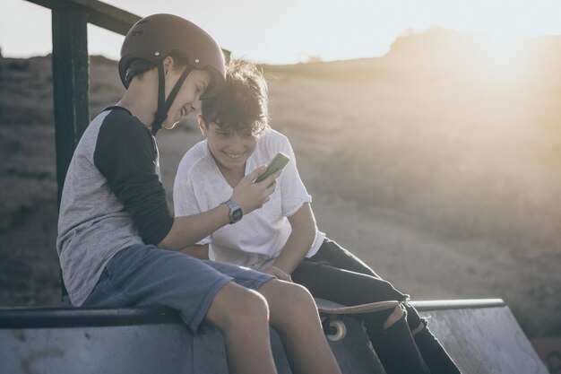 Vrienden kijken naar hun smartphone en glimlachen buiten.