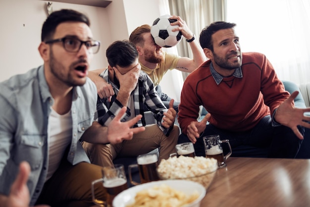 Vrienden kijken naar voetbalwedstrijd