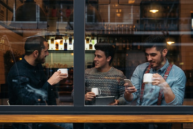 Vrienden koffie drinken en chatten in café.