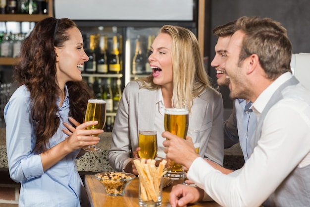 Vrienden lachen terwijl ze bier drinken