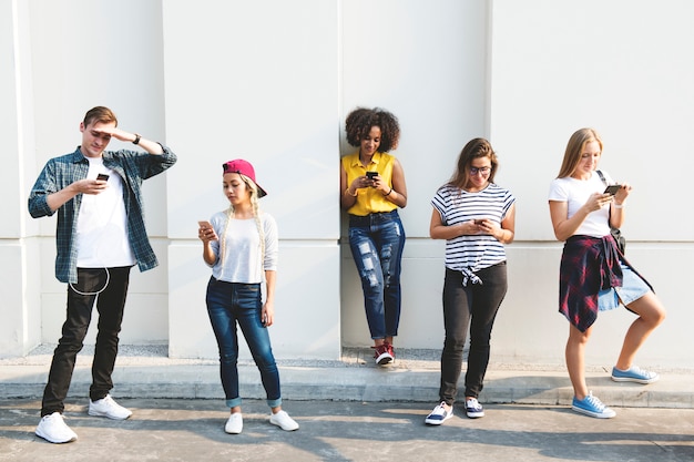 Vrienden met behulp van smartphones buitenshuis samen en chillen