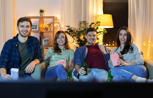 vrienden met bier en popcorn thuis tv kijken