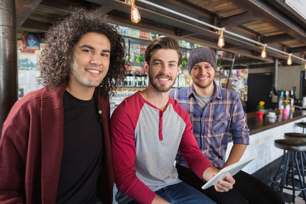 Vrienden met digitale tablet zitten in restaurant