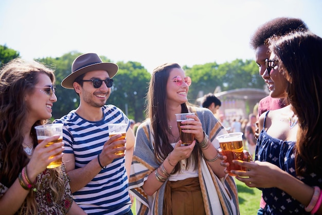 Vrienden met drankjes in glazen terwijl ze tegen de lucht staan.