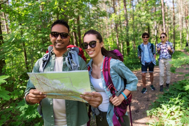 Foto vrienden met kaart en rugzakken wandelen in het bos