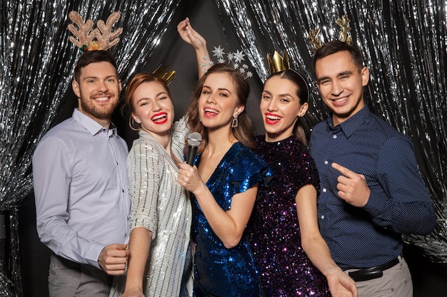 vrienden met microfoon zingen op een kerstfeest