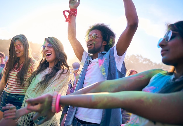 Vrienden met poederverf genieten tegen de lucht tijdens het festival