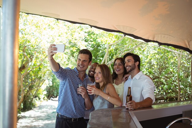 Vrienden nemen selfie terwijl ze alcohol aan de balie hebben