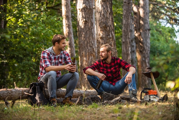 Vrienden ontspannen in het park samen bier drinken bij picknick kampvuur levensverhaal vrije tijd samen doorbrengen familie kamperen wandelen avontuur picknick in toerisme kamp gelukkige mannen broers