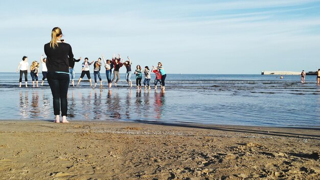 Foto vrienden op het strand tegen de lucht