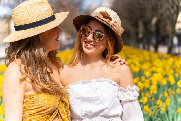 Vrienden op vakantie in de stad naast een aantal mooie gele bloemen die veel glimlachen en genieten van de lente