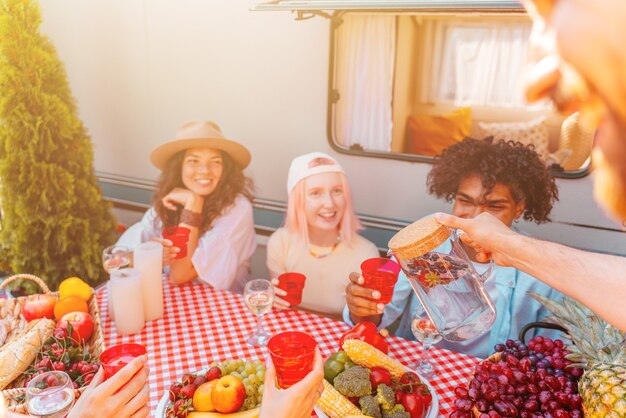 Vrienden picknicken met een camper op een zonnige dag