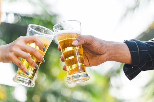 Vrienden rammelende fles bier tijdens het kamperen buiten