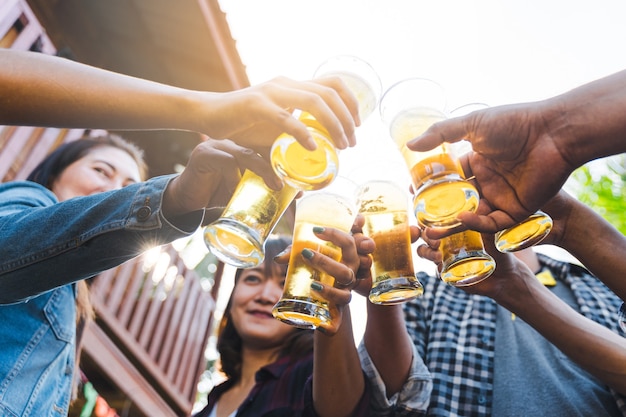 Foto vrienden rammelende fles bier tijdens het kamperen buiten