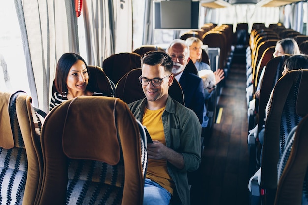 Vrienden reizen met de bus, glimlachen en praten samen.