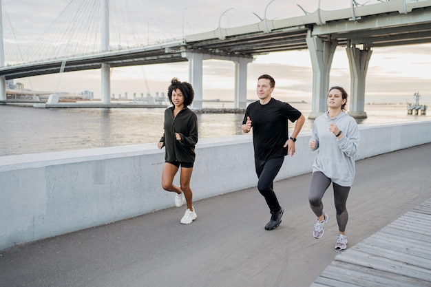 Vrienden rennen rond in sportkleding en sneakers Het concept van volkssporten in de stad