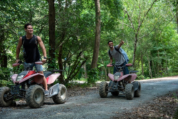 Vrienden rijden ATV door het bos met vreugde en opwinding