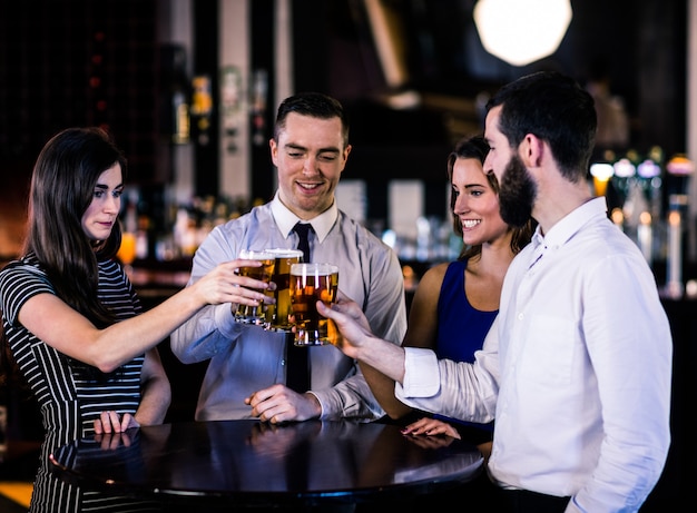 Vrienden roosteren met een biertje in een bar