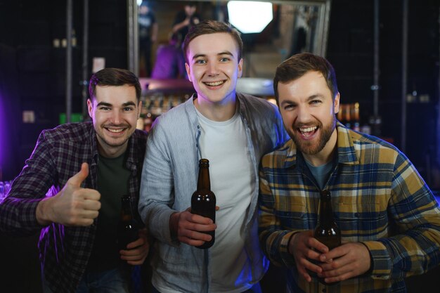 Vrienden rusten in de kroeg met bier in handen Gesprek voeren