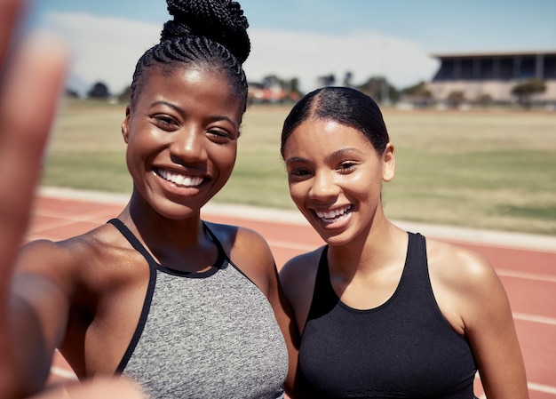 Vrienden selfie en hardlopen met vrouwen op stadionbaan voor training sprinten en uithoudingsvermogen Cardiotraining en sporten met portret van hardloper voor teamwerk, samenwerking en sprinten