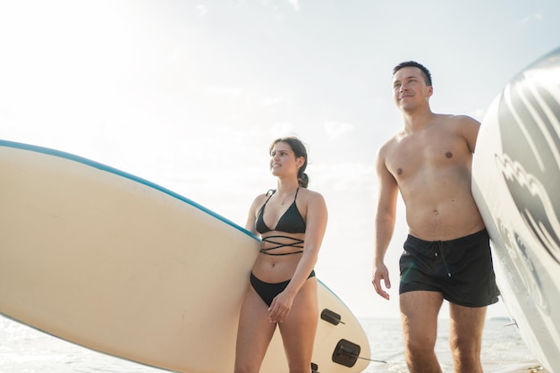 Vrienden van een man en een vrouw tijdens een weekendvakantie rijden op een sup board op zee