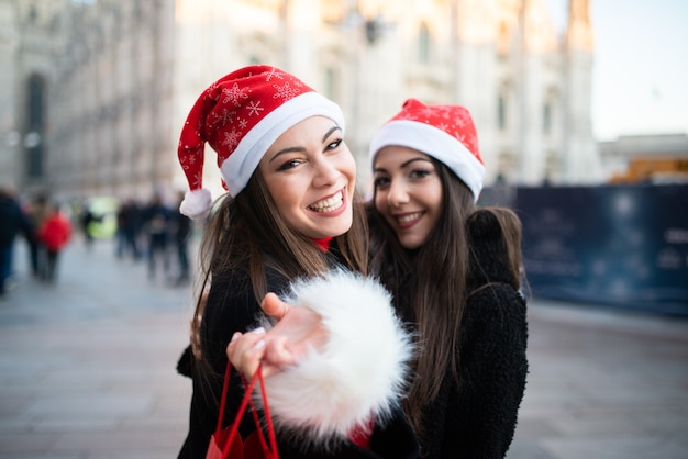 Vrienden van jonge vrouwen die samen winkelen voor Kerstmis