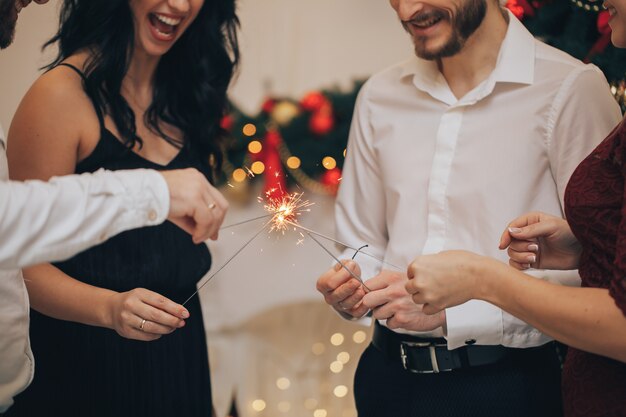 Vrienden vieren Kerstmis of Nieuwjaar vooravond feest met Bengalen lichten