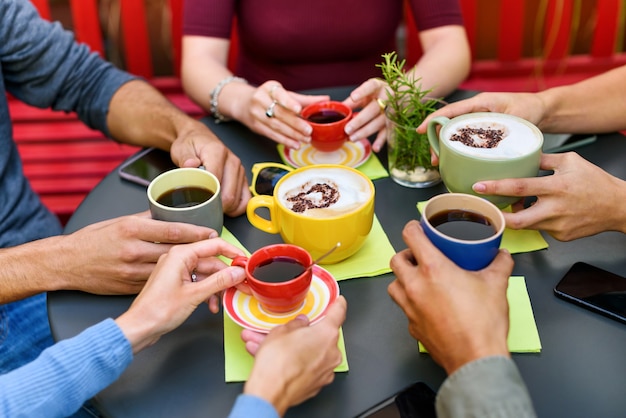 Vrienden zitten aan tafel met kopjes koffie en cappuccino