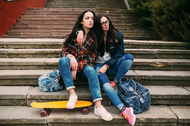 vrienden zitten op de trap met een skateboard