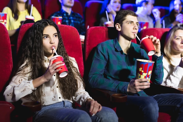 Vrienden zitten samen en eten popcorn terwijl ze films kijken in een bioscoop