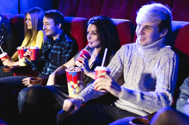 Foto vrienden zitten samen popcorn te eten terwijl ze films kijken in een bioscoop