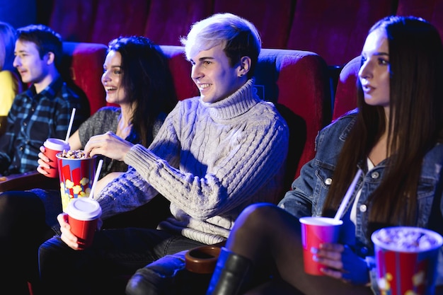 Vrienden zitten samen popcorn te eten terwijl ze films kijken in een bioscoop