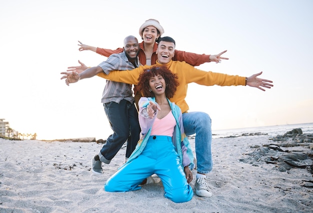 Vriendenstrand en portret van opgewonden mensen buiten voor reismotivatie of plezier op zand Diversiteitsgeluk en gen z groep mannen en vrouwen wijzend op avontuurlijke vakantie en vrijheid in de natuur