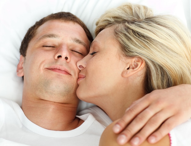 Foto vriendin die haar vriend in bed kussen