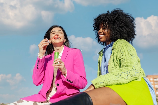 Foto vriendinnen bellen blazen in een buitenveld