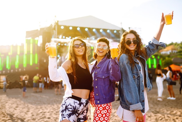 Vriendinnen die bier drinken en plezier hebben op muziekfestival Vriendschap en viering Zomervakantie