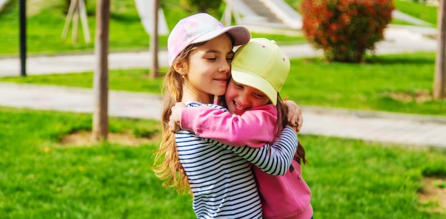 Vriendinnen kinderen knuffelen in de parkselectieve focus