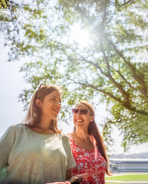 Vriendinnen lopen samen plezier buitenshuis concept van moderne vrouwen vriendschap levensstijl vrouwelijke beste vrienden gelukkige meisjes reizen op pauze of stadsvakantie heldere warme dag vrolijk lachen