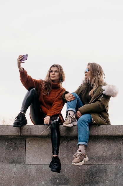 Foto vriendinnen nemen selfie buitenshuis samen