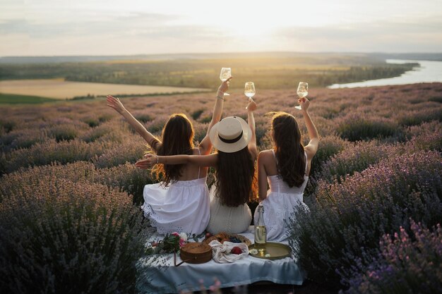 Foto vriendinnen ontspannen op zomerzonsondergang met rivier op de achtergrond