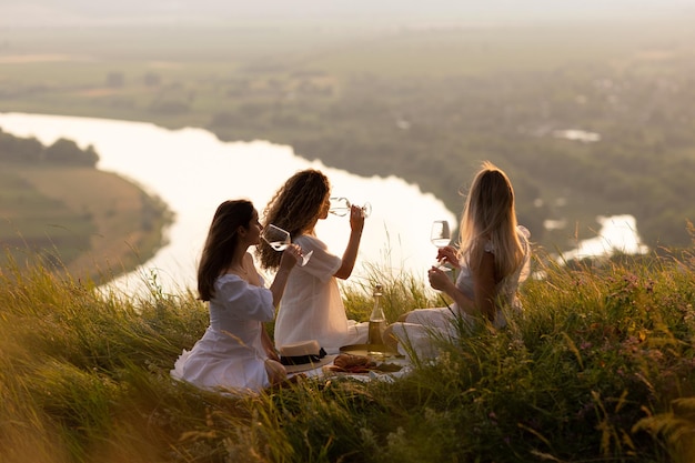 Foto vriendinnen picknicken op de berg bij zonsondergang
